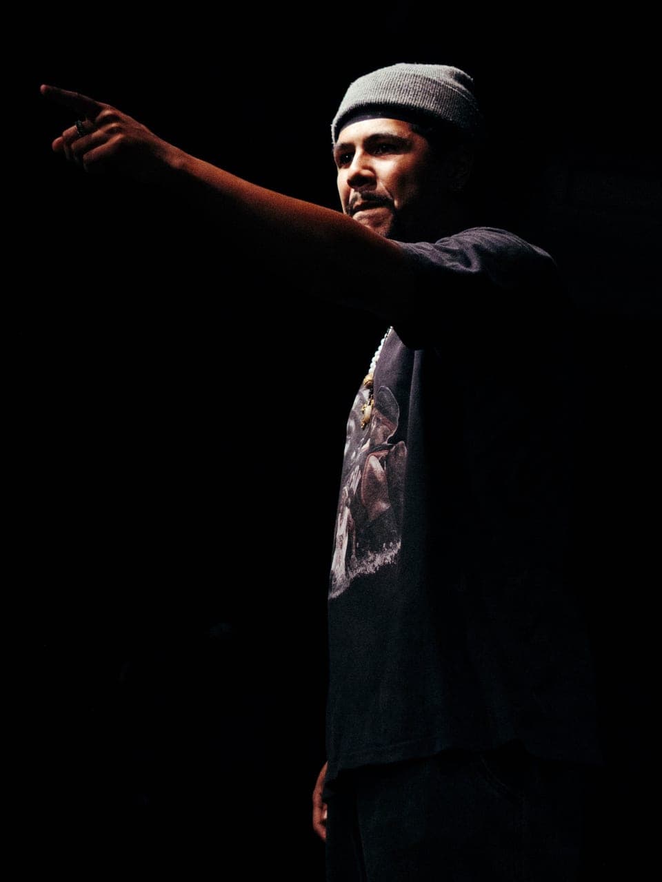 FRK no palco, de touca cinza, apontando para a plateia